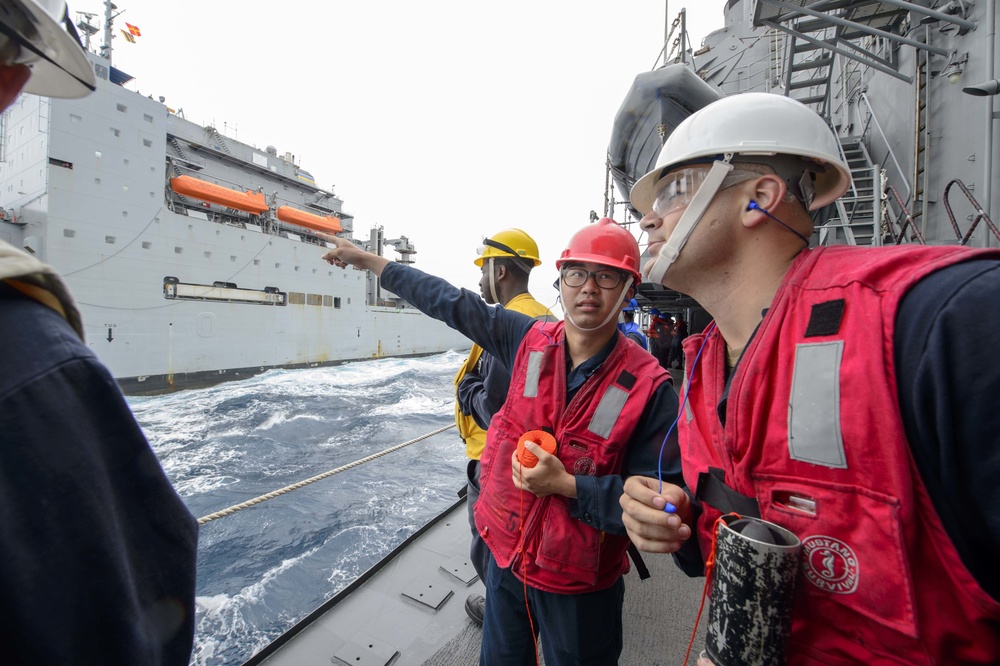 USS Antietam (CG 54) Sailor gives instruction during a replenishment at sea (RAS) with USNS Cesar Chavez (T-AKE-14)