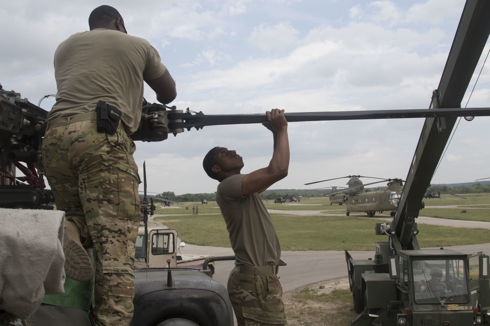 Spc. Kendall Smith and Pvt. Deshawn Simon with Delta Company, 1-130th Attack Reconnaissance Battalion, Task Force Panther, 101st Combat Aviation Brigade, 101st Airborne Division, work to remove a rotor blade from an AH-64D Apache Longbow helicopter at North Fort Hood, Texas, on May 19, 2018.