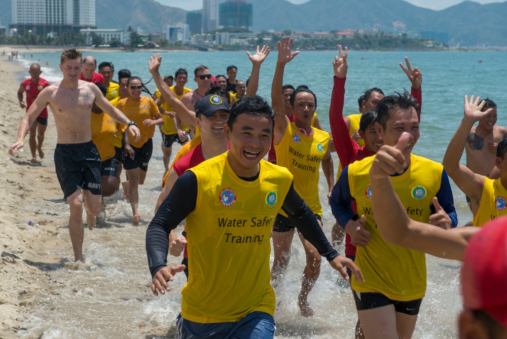 PP18 servicemembers join Vietnamese swimmers in a surf lifesaving event.