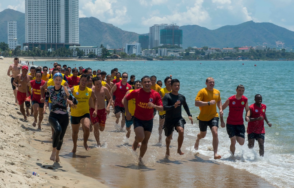 PP18 servicemembers join Vietnamese swimmers in a surf lifesaving event.