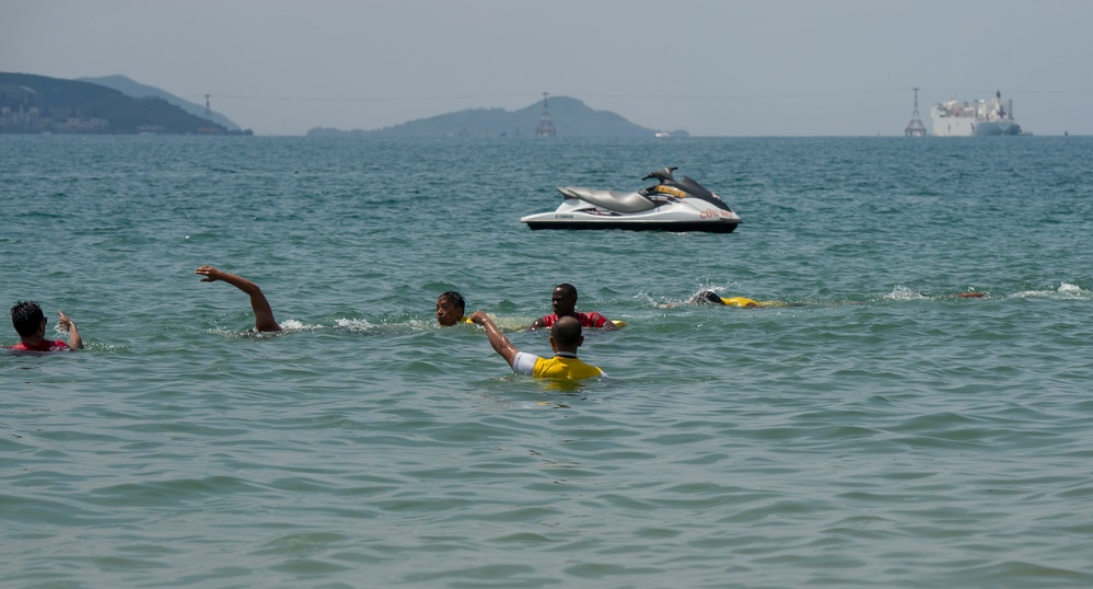 PP18 servicemembers join Vietnamese swimmers in a surf lifesaving event.
