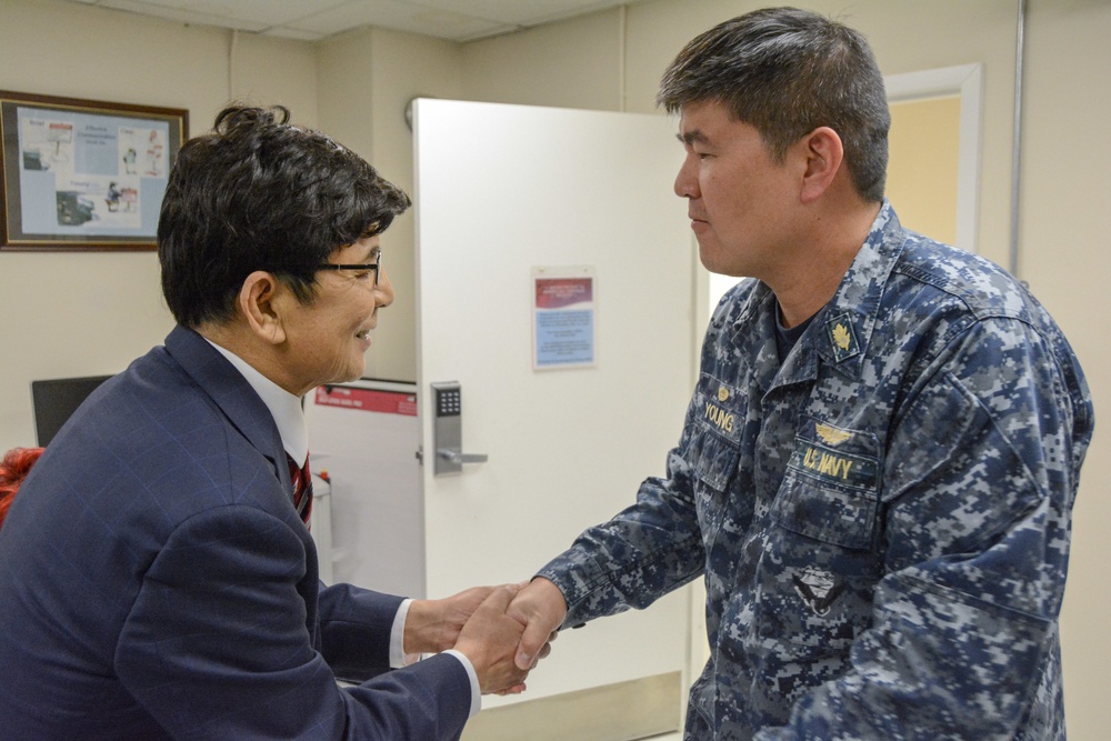 Henry Kim is presented a coin by NHCPR Commanding Officer