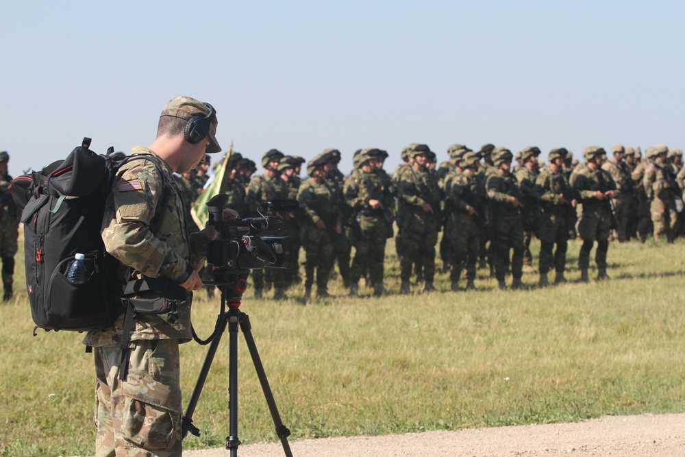 Spc. Steven Selis of the Michigan Army National Guard, 126th Press Camp Headquarters, records the opening ceremony of Saber Strike 18