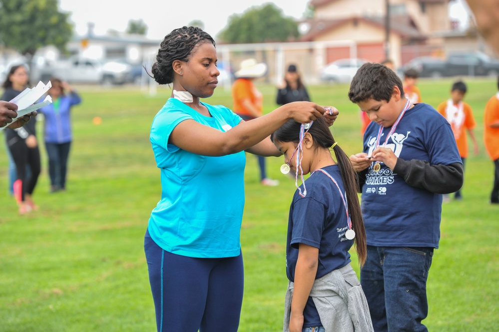 USS America Sailor awards medals at children's sports day event