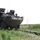 Polish soldier guides a U.S. Army Stryker