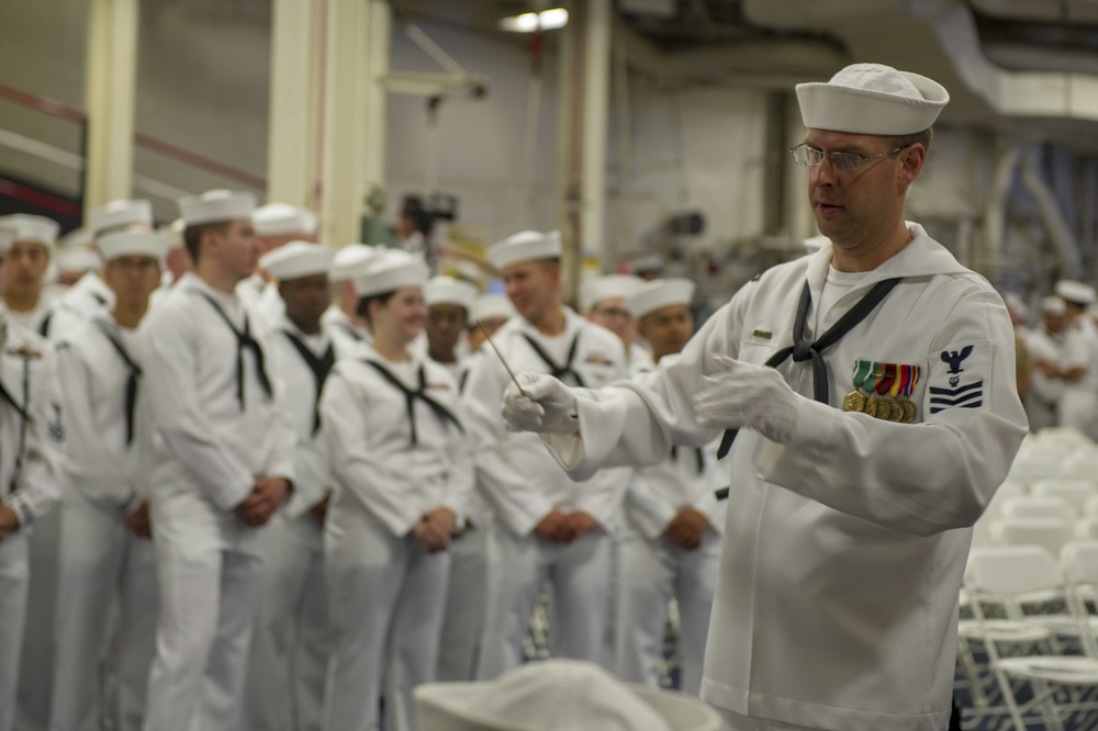 USS America Sailor conducts band during ceremony