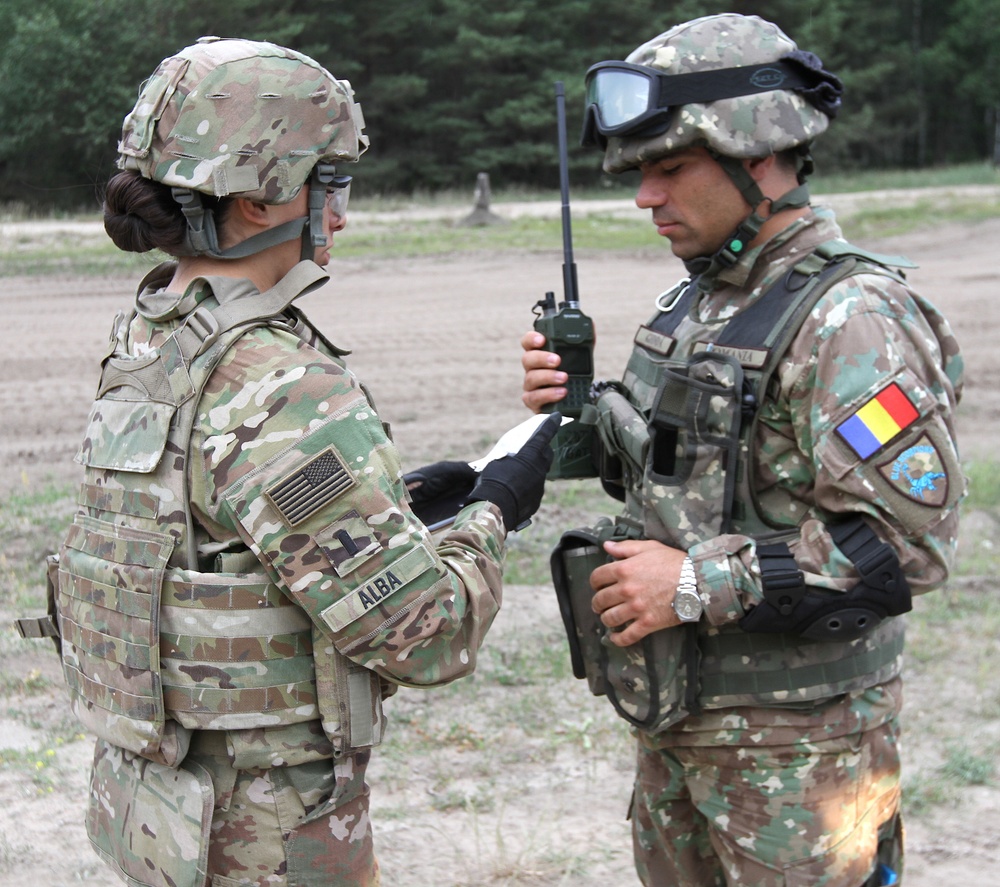 U.S. Army officer briefs a Romanian soldier on vehicle order