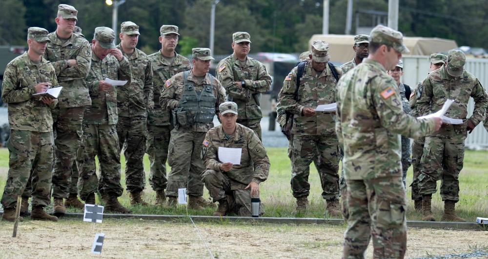Soldier leaders conduct mission brief at the sand table in Tactical Training Base Kelley