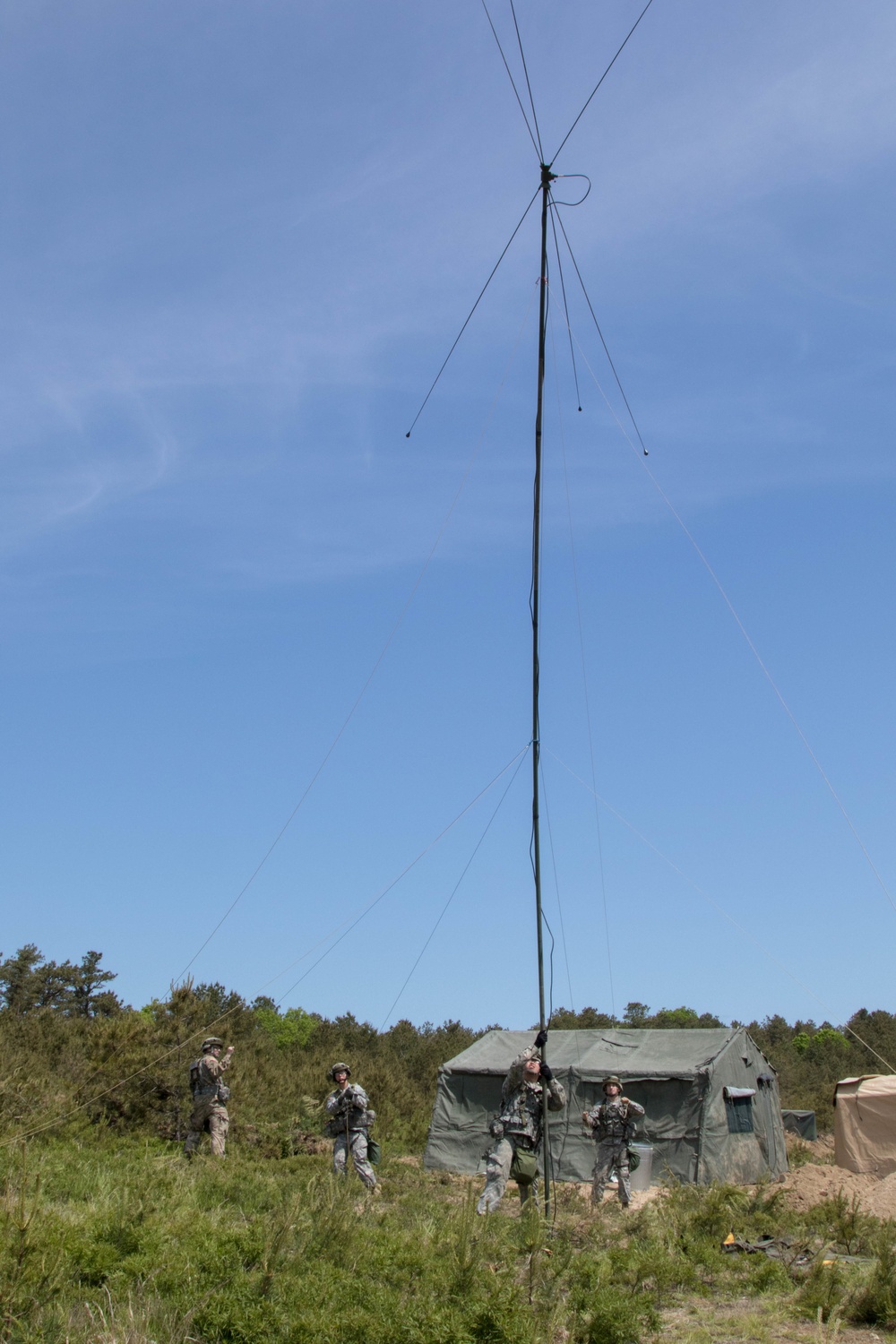 Soldiers raise antenna at dig site as part of training exercise