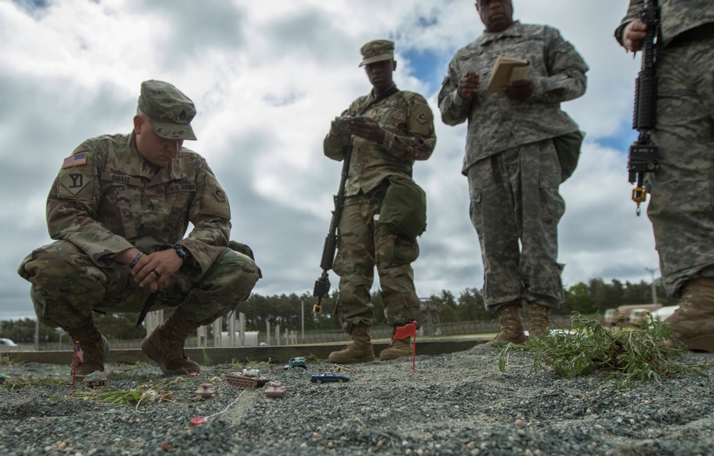 Soldier conducts mission brief at a sand table in Tactical Training Base Kelley