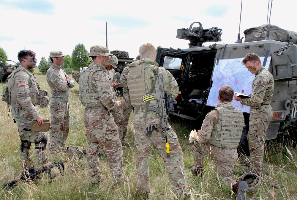 U.K. soldier briefs other soldiers on enemy intel