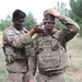 U.S. soldier applies camouflage to battle buddy