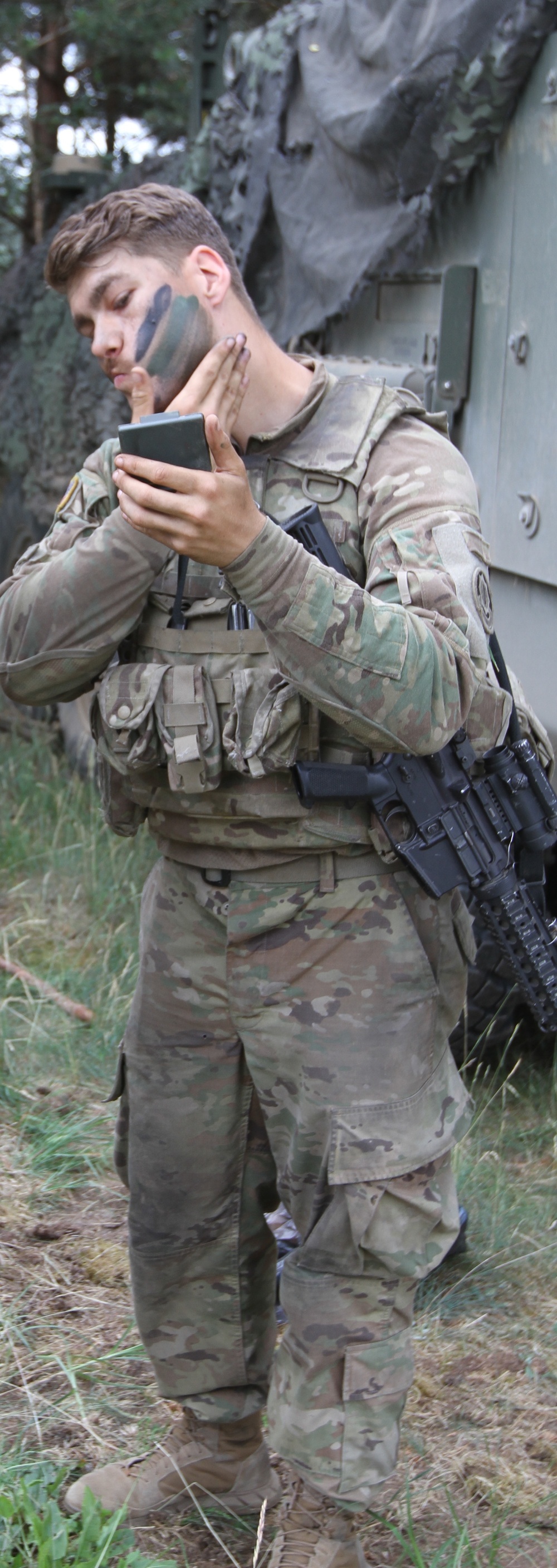 U.S. soldier applies camouflage during Saber Strike 18
