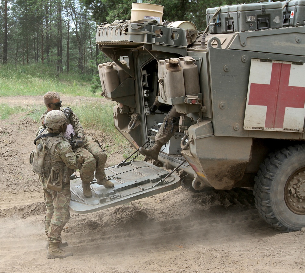 U.S. Army soldier loads simulated injured soldier into Medical Evacuation Vehicle