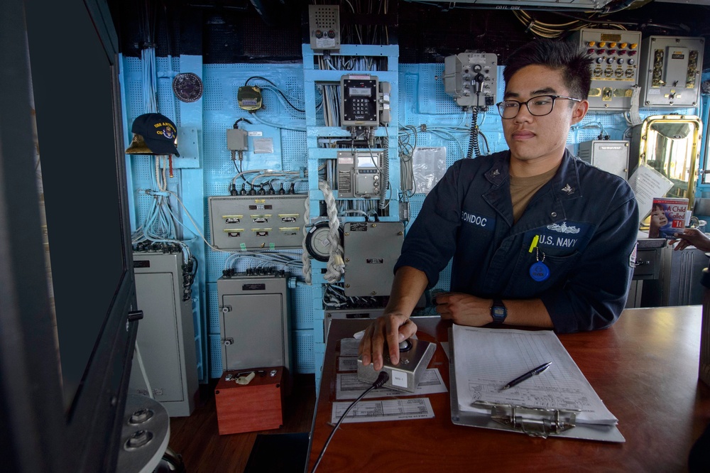 USS Antietam (CG 54) Sailor assists with navigation in the ship’s bridge during Malabar 2018