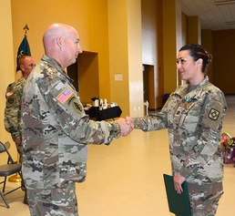Capt. Erin Montoya, outgoing commander of the 200th Public Affairs Detachment, 93rd Troop Command, New Mexico Army National Guard, shakes hands with Col. Michael A. Treadwell, 93rd Troop Command commander.