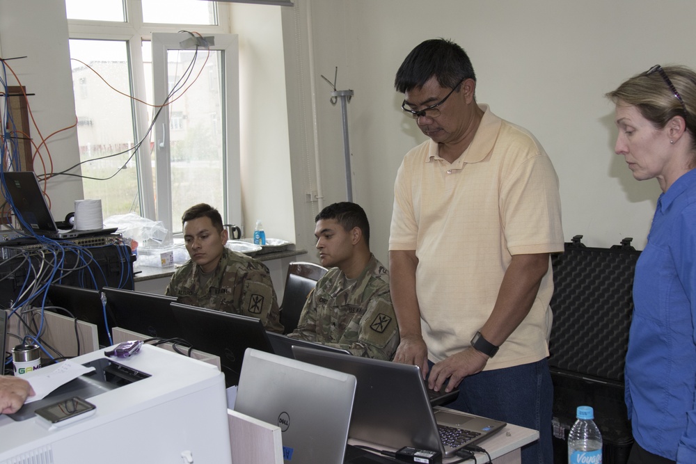 U.S Army Soldiers work with civilian counterparts to ensure network operations run smoothly.