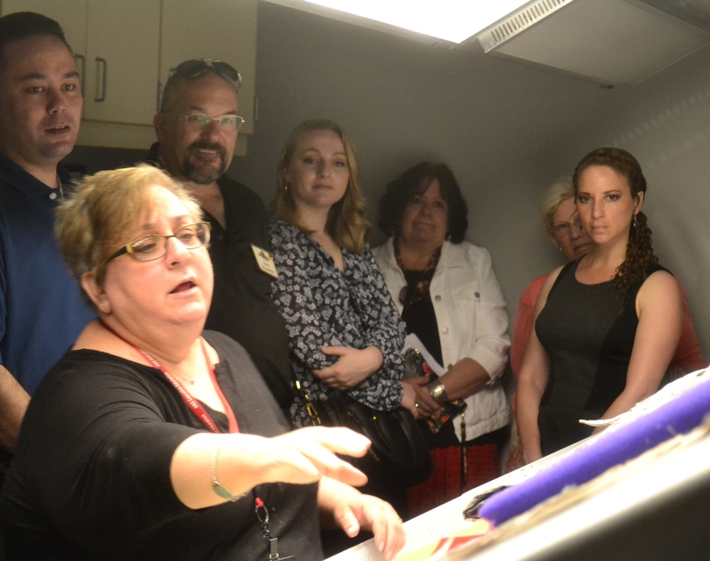 Members of the Greater Northeast Philadelphia Chamber of Commerce listen as Defense Logistics Agency Troop Support's Product Test Center Analytical supervisor Jamie Hieber provides a tour of the test center's shade room in Philadelphia June 18.