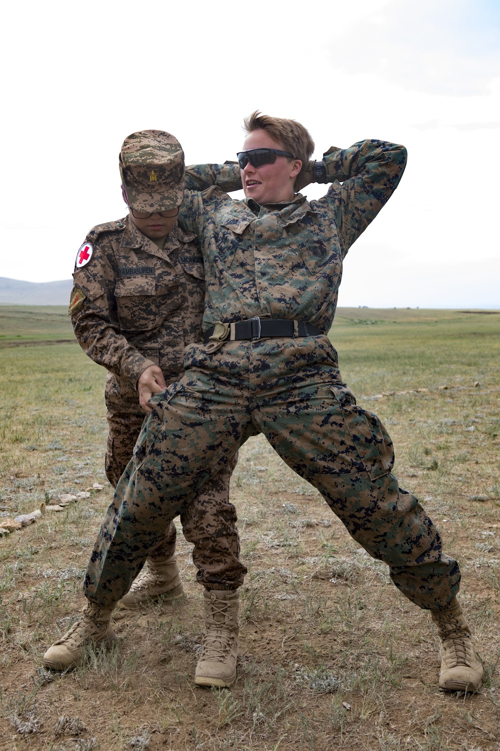 A Mongolian Armed Forces soldier searches U.S Marine Corps Sgt. Arielle Lahtinen.