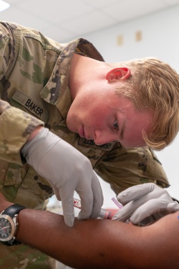 Pfc. Baker draws blood during the physical health assessment