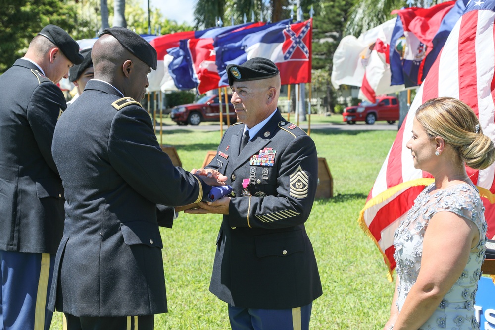 Command Sgt. Maj. Sergio Ortega receives the American flag