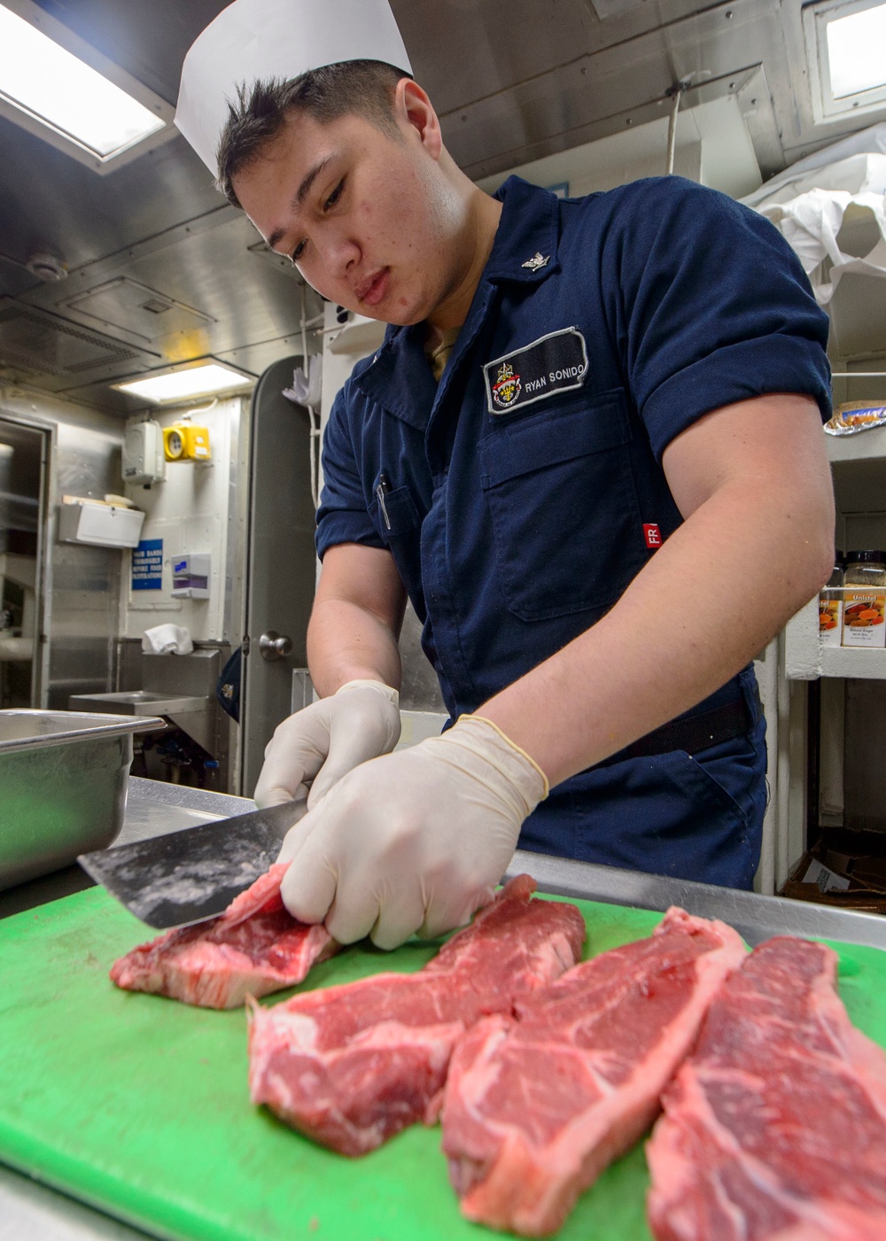 USS Antietam (CG 54) Sailor prepares food in the ship’s galley