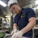USS Antietam (CG 54) Sailor prepares food in the ship’s galley