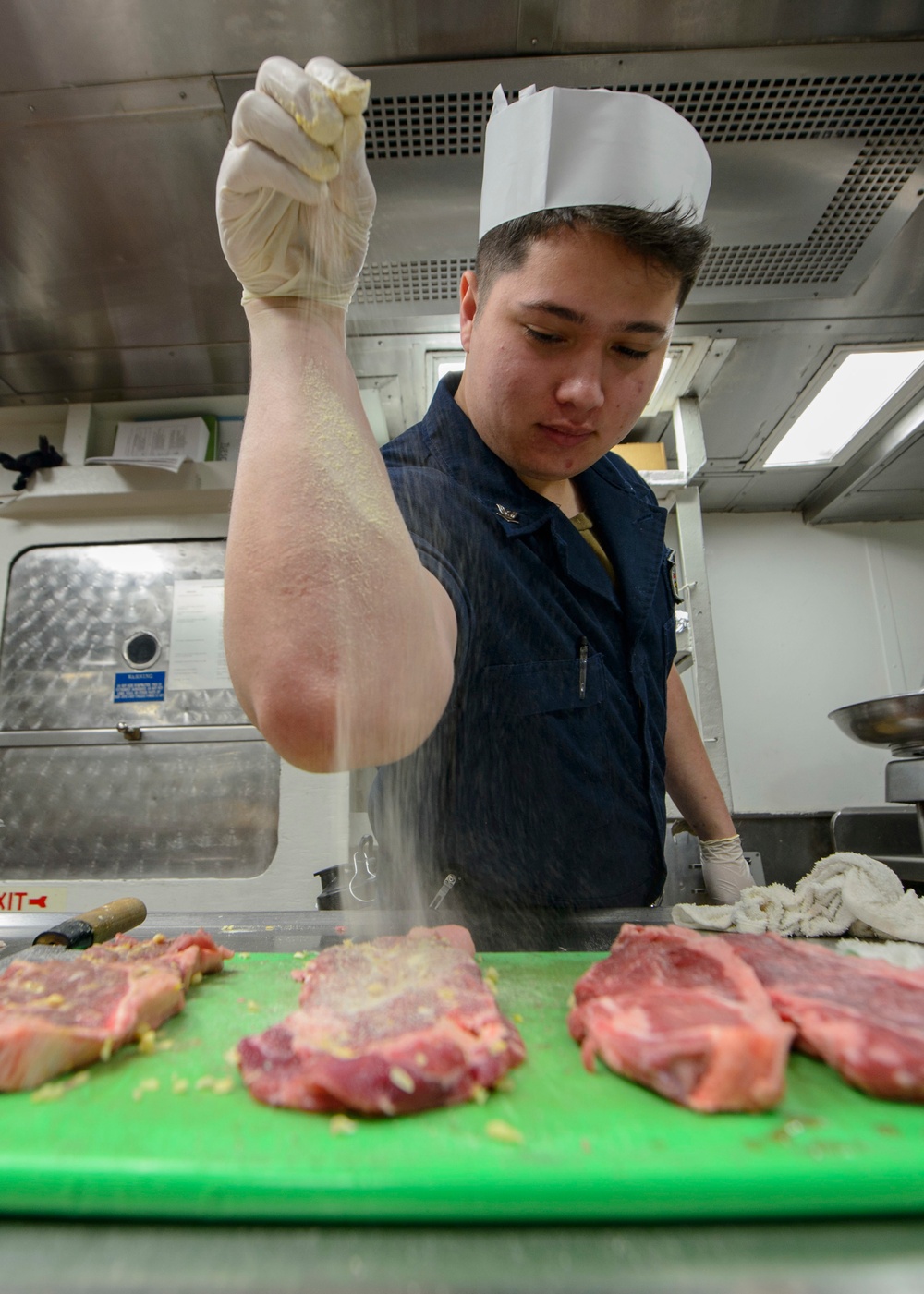USS Antietam (CG 54) Sailor prepares food in the ship’s galley