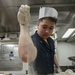 USS Antietam (CG 54) Sailor prepares food in the ship’s galley