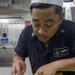 USS Antietam (CG 54) Sailor prepares food in the ship’s galley