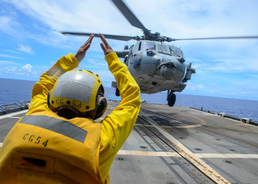 USS Antietam (CG 54) Sailor directs a helicopter on to the ship’s flight deck