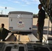 Coast Guard Pacific Strike team members and an Air Station Barbers point aircrew load decontamination gear for RIMPAC exercise