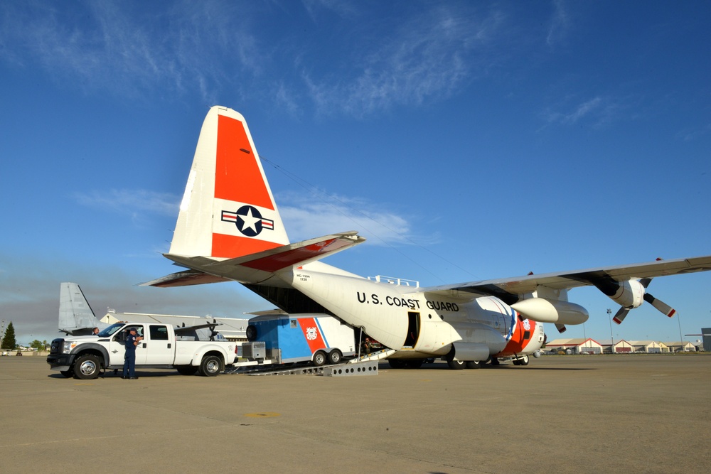 Coast Guard Pacific Strike team members and an Air Station Barbers point aircrew load decontamination gear for RIMPAC exercise