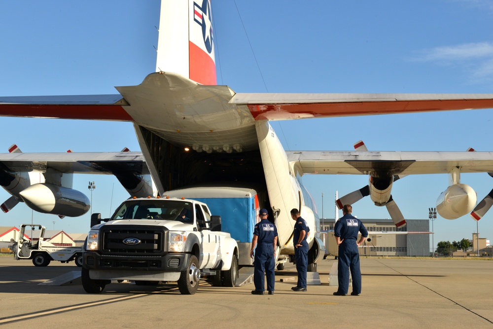 Coast Guard Pacific Strike team members and an Air Station Barbers point aircrew load decontamination gear for RIMPAC exercise