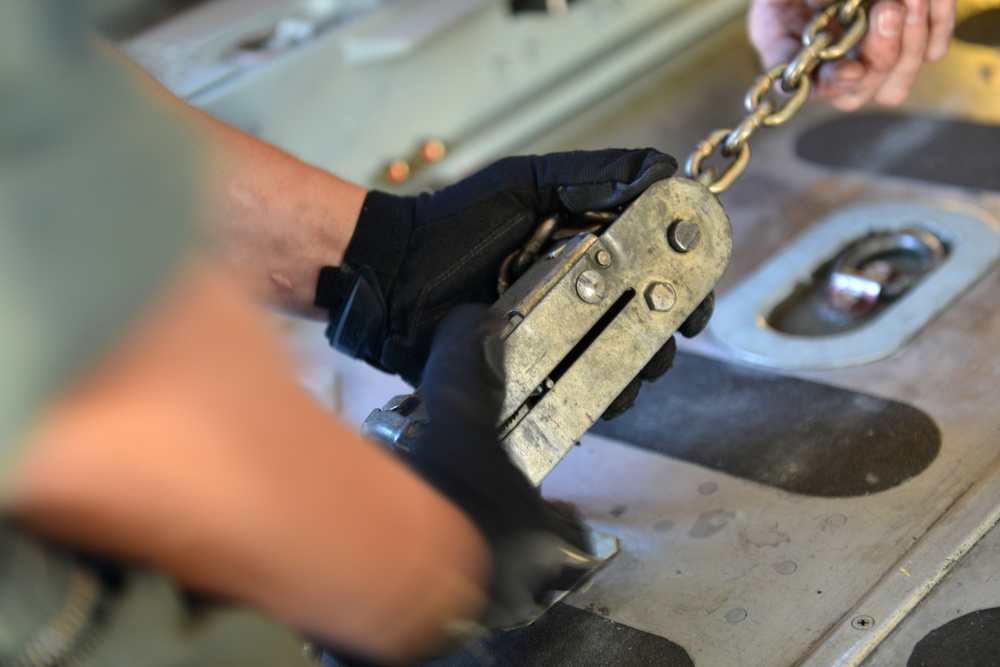 Coast Guard Pacific Strike team members and an Air Station Barbers point aircrew load decontamination gear for RIMPAC exercise