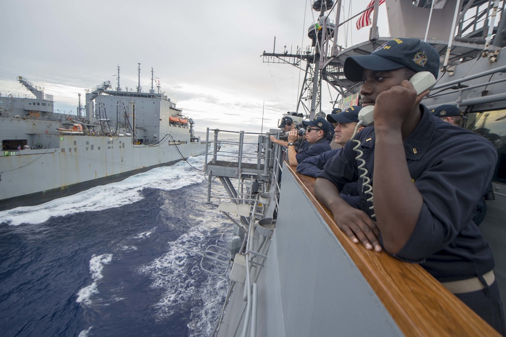 USS Antietam (CG 54) junior officer communicates with USNS Cesar Chavez (T-AKE-14) during an underway replenishment