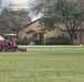 JBSA-Lackland Grounds Maintenance worker cutting grass in field