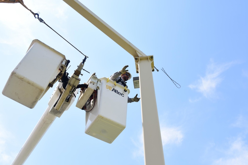A 502nd Civil Engineer squadron high voltage team re-attaches the cover over Medina Base Gate