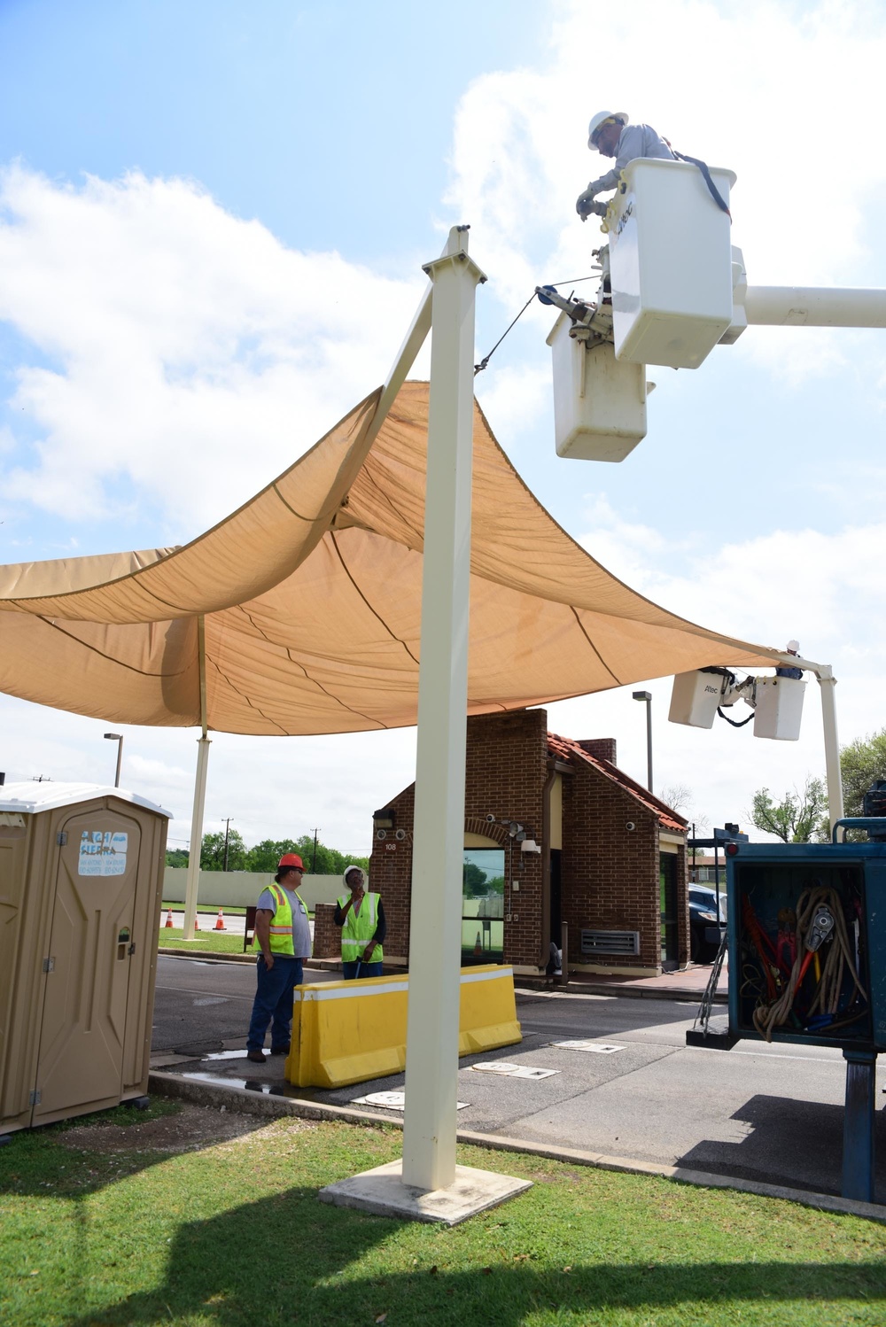A 502nd Civil Engineer squadron high voltage team re-attaches the cover over Medina Base Gate
