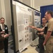 Reed explains poster at conference