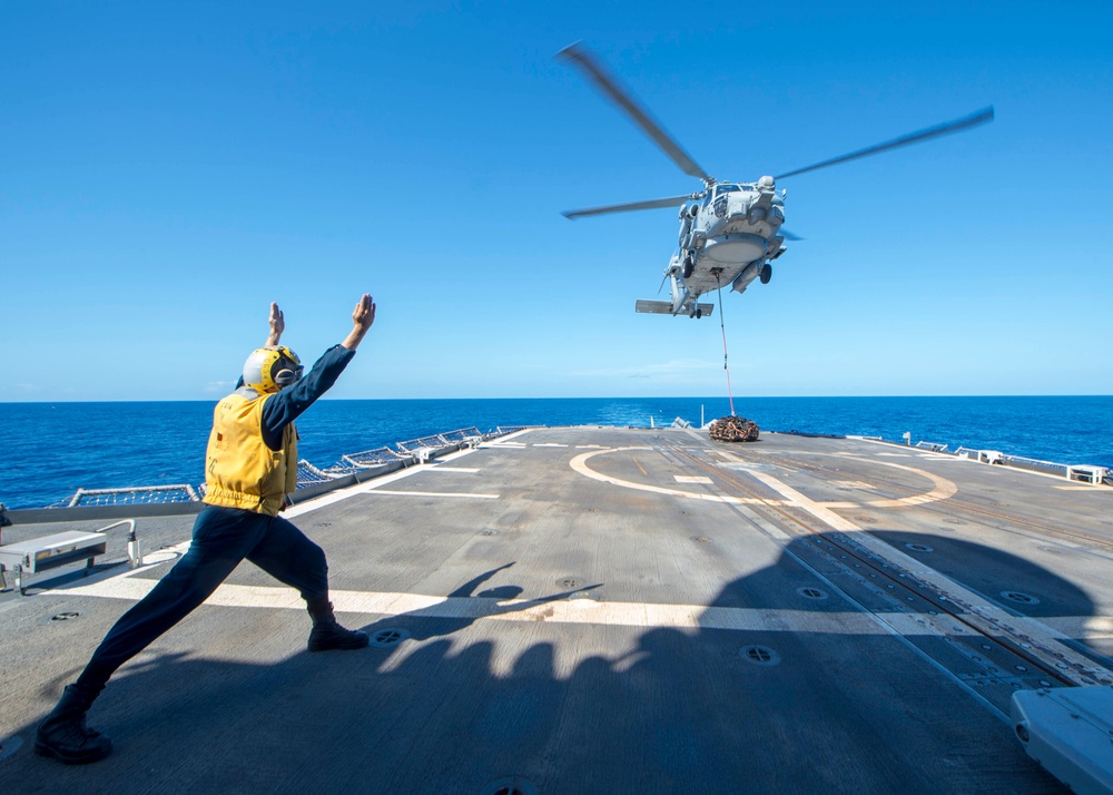 USS Antietam (CG 54) Sailor signals to a MH-60R Sea Hawk helicopter from “Warlords” of HSM 51