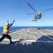 USS Antietam (CG 54) Sailor signals to a MH-60R Sea Hawk helicopter from “Warlords” of HSM 51