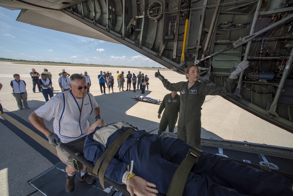 A flight nurse loads medical patients on a C-130 Hercules