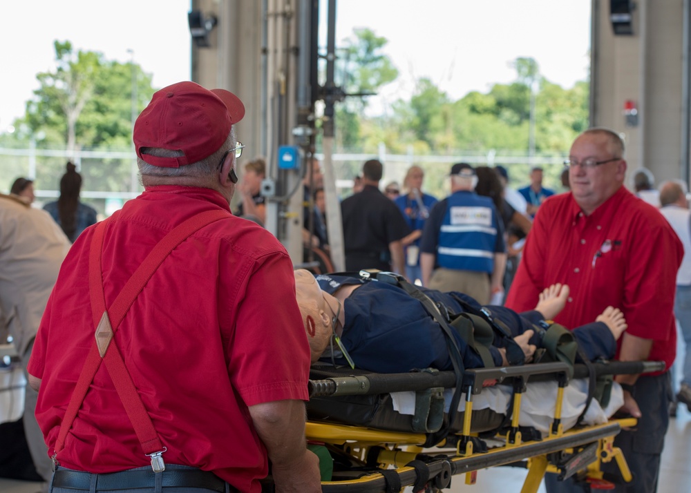 EMTs move simulated patient into an ambulance