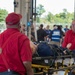 EMTs move simulated patient into an ambulance