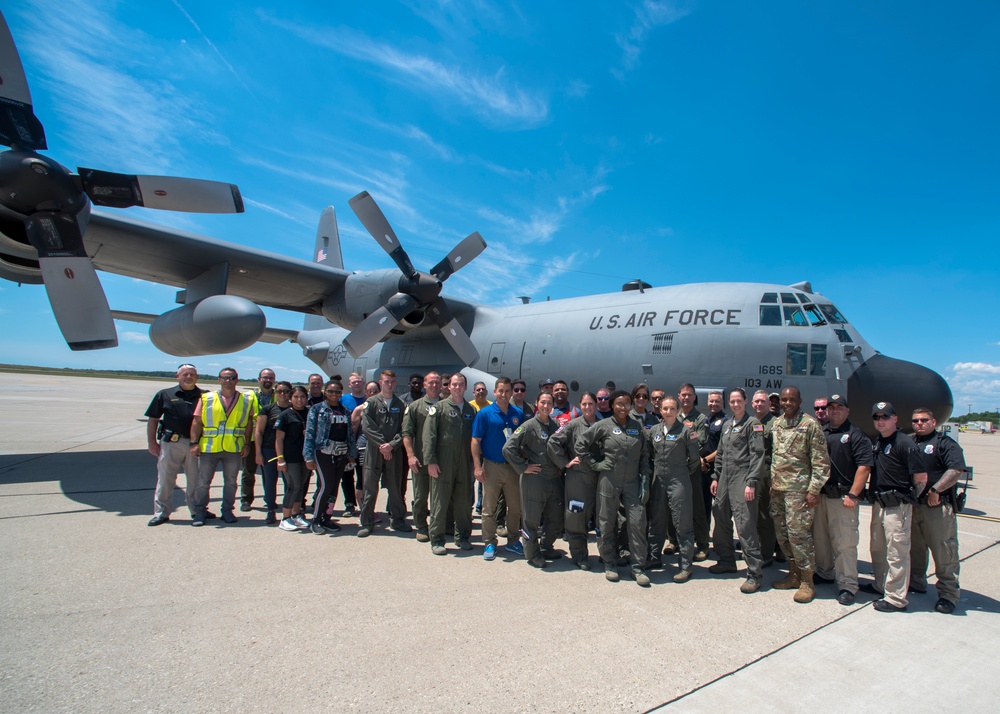 Emergency responders take photo in front of C-130 Hercules