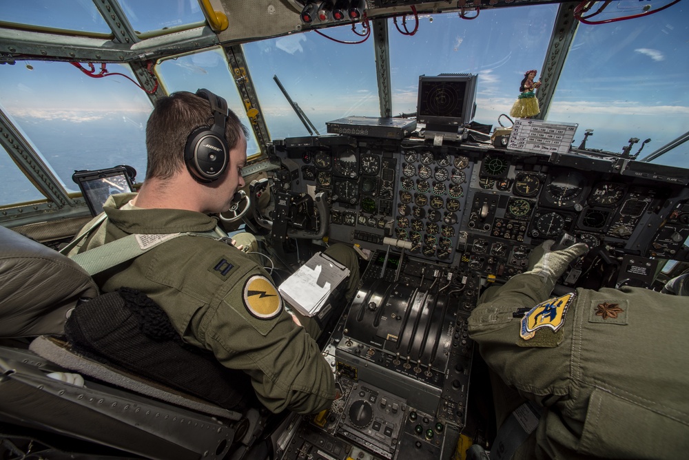 Pilots fly a C-130 Hercules