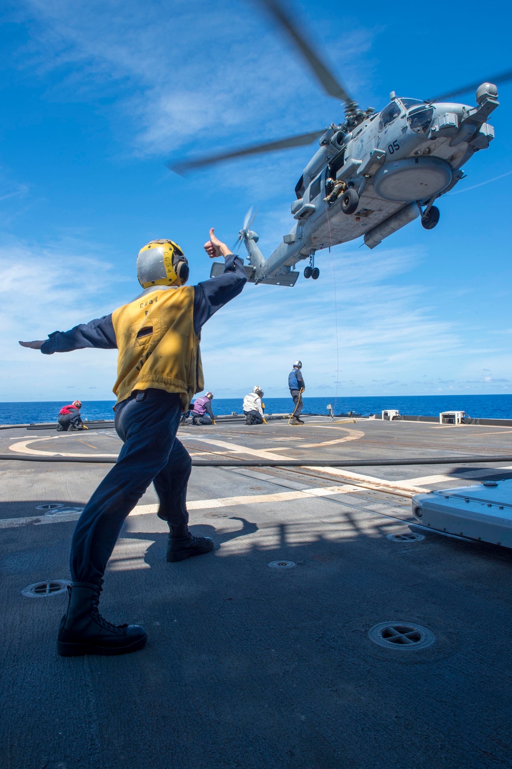 USS Antietam (CG 54) Sailor signals to MH-60R Sea Hawk during an in-flight refueling