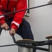 Coast Guard crew member secures a line to set of bitts