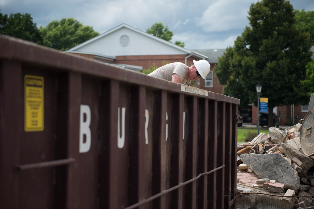 Staff Sgt. Daniel Arnold cleans up waste at the West Virginia Schools for the Deaf and the Blind